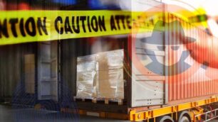 A dry van trailer backed up to a loading dock with caution tape over it