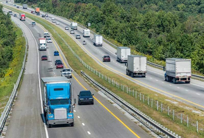 Semi trucks and other vehicles going down a highway
