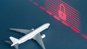 An airplane approaching a red wall with a lock on it