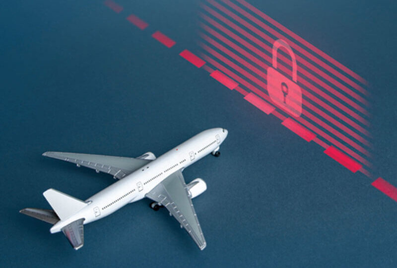 An airplane approaching a red wall with a lock on it