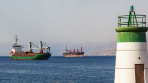 Cargo ships in the Red Sea with a small lighthouse on a shore